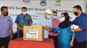  ?? OF SABAH CHIEF MINISTER’S OFFICE PIC COURTESY ?? Sabah Chief Minister Datuk Seri Hajiji Noor (centre) presenting food aid from Maxis to Arnas Merah, 70, in Tuaran yesterday.