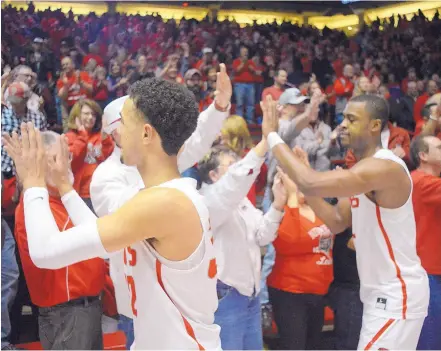  ?? ADOLPHE PIERRE-LOUIS/JOURNAL ?? Anthony Mathis, left, and Sam Logwood high-five fans after the Lobos defeated UNLV 91-90 at Dreamstyle Arena — the Pit on Sunday. UNM’s attendance has been in the top 25 for the first 50 years in the Pit but is finishing outside the top 25 for the...