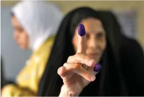  ?? צילום: אי.פי ?? אזרחית ותיקה מראה את כתם הדיו על אצבעה, לאחר שהצביעה בקלפי בבגדד בבחירות הכלליות שנערכו אתמול בעיראק