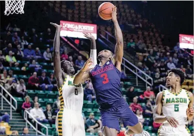  ?? DAVID JABLONSKI / STAFF ?? Dayton’s Trey Landers drives to the basket against George Mason’s Goanar Mar during the Patriots’ 85-67 home victory over the Flyers on Wednesday. Landers finished with six points in 17 minutes.