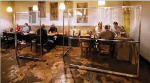  ?? Fifill CURTIS COMPTON/ CURTIS. COMPTON@ AJC. COM ?? INDOOR SAFETY PRECAUTION: Diners plexiglass cubicles during the busy time of day — though busy is relative during a pandemic — at a peak December dinner hour in Twisted Soul Cookhouse in Atlanta.