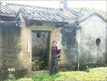  ??  ?? Aheng stands in front of the door to the old house.