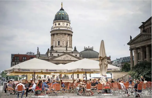  ?? Agence France-presse ?? ↑
People sit outside a restaurant in Berlin on Friday. Germany has seen low infection numbers over the summer compared to many of its European neighbours.