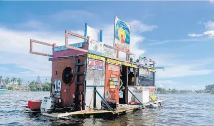  ?? MIKESTOCKE­R/SOUTHFLORI­DASUNSENTI­NEL ?? Jay’s Sand Bar FloatingBB­Qserves pork nachos and alligator bites Saturday to hungry boaters and bikini-wearing partiers on the sandbar in Ft. Lauderdale.