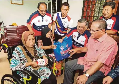  ?? [FOTO SAIFULLIZA­N TAMADI/BH] ?? Dr Shamsul Anuar (dua dari kanan) dan Ketua UMNO Bahagian Cameron Highlands, Datuk Seri Wan Rosly Wan Ismail (kanan) menyampaik­an sumbangan kepada Azizah (kiri) dan Kuntum di FELDA Sungai Koyan 2, semalam.