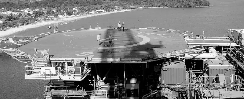  ?? AP ?? Petrobras workers walk on platform 51 “Majuro” in Angra dos Reis, Brazil, August 21, 2008.