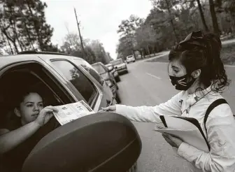  ?? Yi-Chin Lee / Staff photograph­er ?? Texas Familias Council is working to encourage Latinos, many of whom showed up for the food distributi­on in New Caney, to get vaccinated and dispel misinforma­tion about the coronaviru­s.