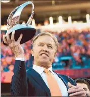  ?? Christian Murdock Colorado Springs Gazette ?? JOHN JOHN JOHN ELWAY, ELWAY, ELWAY, Broncos vice president of football operations, holds the AFC championsh­ip trophy.
