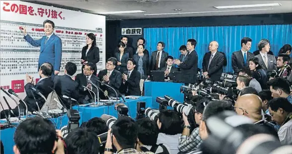  ?? TOMOHIRO OHSUMI / BLOOMBERG ?? El primer ministro japonés, Shinzo Abe, rodeado de cámaras durante el recuento de los resultados en la sede de su partido, el PLD