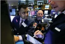  ?? RICHARD DREW — THE ASSOCIATED PRESS FILE ?? Specialist Dilip Patel, left, works at his post on the floor of the New York Stock Exchange.