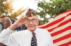  ?? [PHOTO BY JESSIE NEWELL] ?? Rev. Bill Shaw, a World War II veteran and Christian Church (Disciples of Christ) minister, gives a salute during a 2016 photo shoot at Jessie Newell’s Shawnee home. Shaw, 92, died in April 2018.