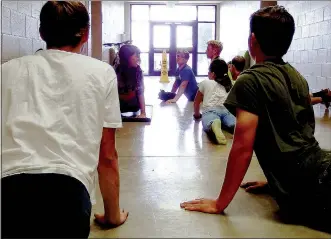  ?? TIMES photograph by Annette Beard ?? On a rainy afternoon, instead of cycling and practicing sharp turns, cyclists stretched and exercised under the guidance of coach Anya Bruhin. “You get out of it what you put into it,” one boy said.