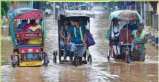  ??  ?? People cross a street flooded by heavy monsoon rain in Guwahati, Assam, India. EPA