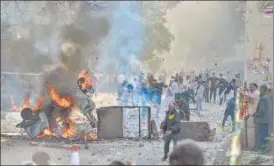  ?? PTI ?? People throw stones during clashes at Jafrabad in north-east Delhi on Monday.