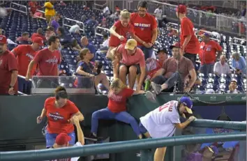  ?? Associated Press ?? Fans jump into a camera well after hearing gunfire from outside Nationals Park Saturday.