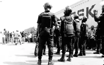  ??  ?? Ivory Coast security forces stand in front of demobilise­d ex-rebel fighters at the checkpoint at the entrance of Bouake, Ivory Coast. — AFP photo