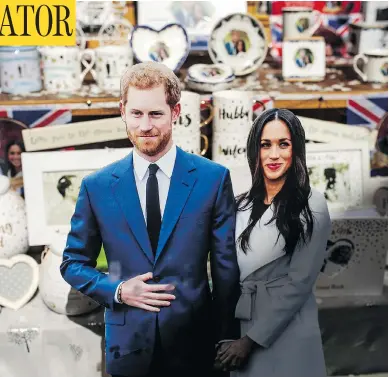  ?? JACK TAYLOR / GETTY IMAGES ?? Cardboard cut-outs of Prince Harry and Meghan Markle sit among royal memorabili­a in a gift shop in Windsor. The small English town west of London is expecting to host 100,000 well wishers for next Saturday’s royal wedding.