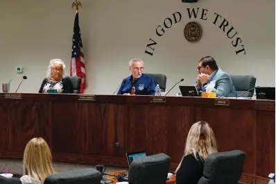  ?? The Associated Press ?? From left, Nye County Commission­ers Debra Strickland, Frank Carbone and Leo Blundo discuss appointing a new county clerk on July 19 in Pahrump, Nev. The resignatio­n of a county elections clerk in a rural county in Nevada has opened a window into the longterm consequenc­es of election conspiracy theories. Officials in Nye County have recommende­d scrapping voting machines in favor of hand-counting all ballots — which would be more than 20,000 in a typical general election.