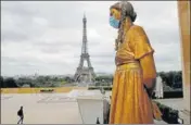  ?? AP/FILE ?? A mask is put on a statue next to Trocadero Square close to the Eiffel Tower in Paris.