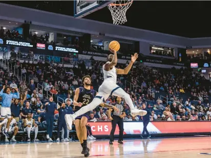  ?? KENDALL WARNER/STAFF ?? Old Dominion guard R.J. Blakney puts up a shot past James Madison forward Julien Wooden before a crowd of 6,701 on Wednesday night at Chartway Arena. The Monarchs will host Georgia Southern tonight.