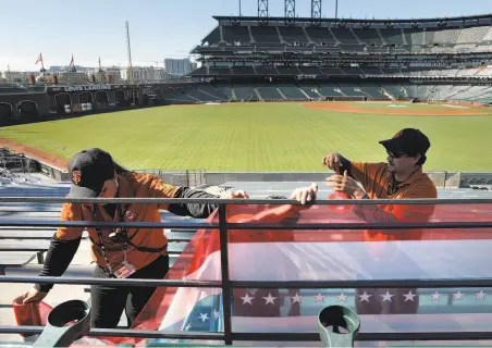  ?? Carlos Avila Gonzalez / The Chronicle ?? In the bleachers, AT&T Park workers spiff up the yard with decorative plastic wrap ahead of Monday’s Game 3 of the NLDS.