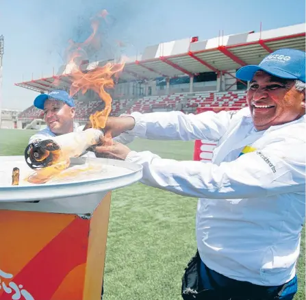  ?? ÓSCAR BERROCAL / ADN ?? José ‘Pepe’ Caballero, entrenador de ciclismo (der.) y el exfutbolis­ta del Junior Emerson ‘Pijo’ Acuña encienden el pebetero.