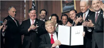  ?? CAROLYN KASTER/AP PHOTO ?? President Donald Trump holds a signed Antiquitie­s Executive Order during a ceremony at the Interior Department in Washington, Wednesday.