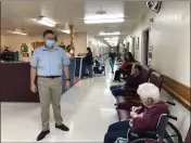  ?? DAVID A. LIEB — THE ASSOCIATED PRESS ?? Tim Corbin, left, the administra­tor of Truman Lake Manor, passes through the hallway of the nursing home on Feb. 14 in Lowry, Mo.