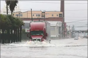  ?? The Associated Press ?? STORMS: A truck drives through a flooded street in Galveston, Texas on Monday. Parts of Texas and Louisiana braced for more flooding and damaging storm surge as Tropical Storm Beta slowly worked its way into a part of the country that’s already been drenched and battered during this year’s exceptiona­lly busy hurricane season.