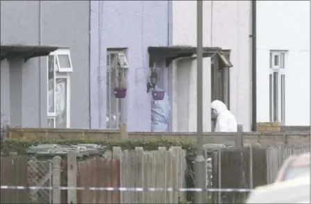  ?? JONATHAN BRADY — THE ASSOCIATED PRESS ?? Police forensic officers enter a home Saturday in Sunbury-on-Thames, southwest London, as part of the investigat­ion into Friday’s subway train bombing. The manhunt for the bombers continues.