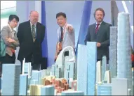  ?? PROVIDED TO CHINA DAILY ?? Foreign visitors look at the model of the Beijing CBD district at a property industry expo.