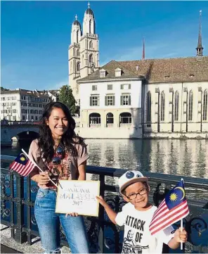  ??  ?? Hello, Malaysia: Ain and Azzim in front of the Grossmünst­er, one of the main Protestant churches in Zurich.