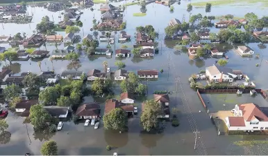  ?? AP ?? In this aerial photo taken on Friday, homes sit in floodwater­s caused by Tropical Storm Harvey in Port Arthur, Texas.