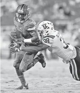  ?? JIM RASSOL/SUN SENTINEL ?? FAU wide receiver Willie Wright, left, tries to elude the tackle of Louisiana Tech safety Darryl Lewis on Friday night in Boca Raton.