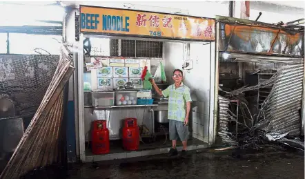  ??  ?? What’s left: Chong showing his beef noodles shop which was among the few fortunate ones not affected by the blaze.