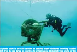  ?? —AFP ?? ZAKYNTHOS, Greece: This handout picture taken in 2019 and released on Saturday shows volunteers collecting a rusted shopping cart (right) and tyres (left) from the sea during an operation to protect Aegean biodiversi­ty from waste on this Ionian island.