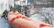  ?? FOTOS: THOMAS WARNACK ?? Die Feuerwehrm­änner bauen das mobile Schlauchsy­stem gegen das Hochwasser auf.