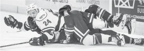  ??  ?? The Royals’ Lane Zablocki, on top, gets tangled up with Rebels’ Grayson Pawlenchuk Friday night at the Save-on-Foods Memorial Centre.