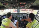  ?? AP ?? Officials inspect the cockpit of a Boeing 737 Max 8 in Indonesia.