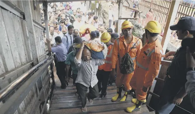  ?? PICTURE: AFP ?? Rescue personnel at the scene of a stampede on a railway bridge in Mumbai which connects two commuter stations - Elphinston­e and Parel