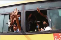  ?? PHOTOS BY THE ASSOCIATED PRESS ?? Arrested protesters wave to people while onboard a bus that is getting out of Insein prison in Yangon, Myanmar, and will transport them to an undisclose­d location Wednesday.