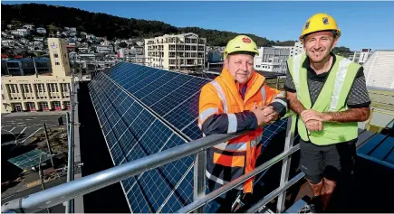  ?? PHOTO: FAIRFAX NZ ?? Ben Cloake, left, sales manager at Sunshine Solar and Chris Sperring, central area manager for YHA New Zealand, atop the Wellington YHA hostel, where solar panels are going in as part of a $2.7m project understood to be the largest solar panel...