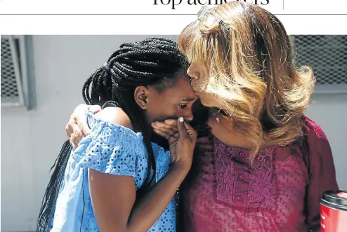  ?? Picture: Esa Alexander ?? Melani Lallo gets a hug and a kiss from school deputy principal Dianne Morgan after she obtained a university entrance pass. Lallo triumphed in the exams despite losing her home twice last year in shack fires in Imizamo Yethu, Hout Bay, and having to...