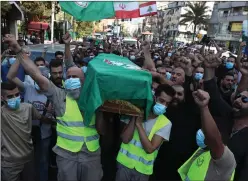  ?? Picture: Bilal Hussein/ap ?? Supporters of the Amal group carry the coffin of one of its members, who was killed in clashes, in the Beirut suburb of Dahiyeh, Lebanon, as soldiers keep guard