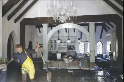  ?? AP ph oto ?? Bill Asher walks through mud in his home damaged by storms in Montecito, Calif. Rescue workers slogged through knee-deep ooze and used long poles to probe for bodies Thursday as the search dragged on for victims of the mudslides that slammed this...