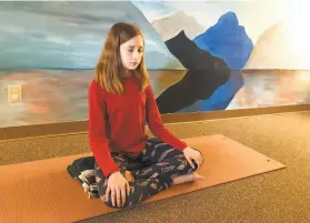  ?? Carolyn Thompson / Associated Press ?? Aeva Schifferli, 12, demonstrat­es a stress-relieving breathing exercise at her mother's yoga studio in East Aurora, N.Y. Students are under increasing stress.