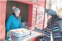  ??  ?? A woman sells maple taffy in Le Domaine de la Forêt Perdue.