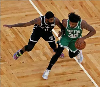  ?? STuART cAHiLL PHOTOs / HeRALd sTAFF ?? LOOK WHO DECIDED TO SHOW UP: Brooklyn’s Kyrie Irving defends Marcus Smart during Friday’s preseason game at TD Garden. Below, Jaylen Brown drives by Brooklyn’s DeAndre Jordan for a layup.