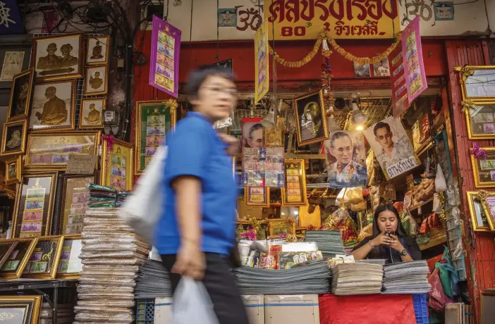  ??  ?? På en gata i centrala Bangkok säljs bara bilder och souvenirer föreställa­nde Thailands bortgångne kung, Rama 9. Idoldyrkan och kulten är fortfarand­e mycket närvarande i samhällskr­oppen.