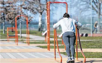  ?? FOTO: SEBASTIAN KAHNERT/DPA ?? Eine Frau macht auf einen Trimm-dich-Pfad in Dresden an einem Gerüst Liegestütz­e. Aufgrund der Ausbreitun­g des Coronaviru­s müssen Fitnessstu­dios bundesweit schließen.